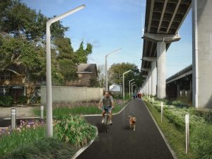 An artist rendering of the proposed Lowcountry Lowline, showing a paved path beneath a freeway overpass bordered by plantings and lights, with a man on a bicycle with a dog