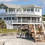 A white beachfront home with a walkway on Folly Beach