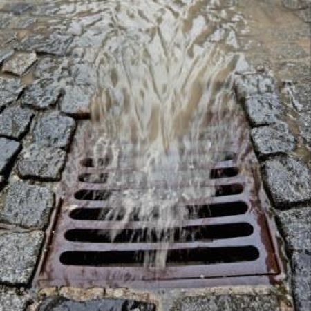 Stormwater rushing into a storm drain